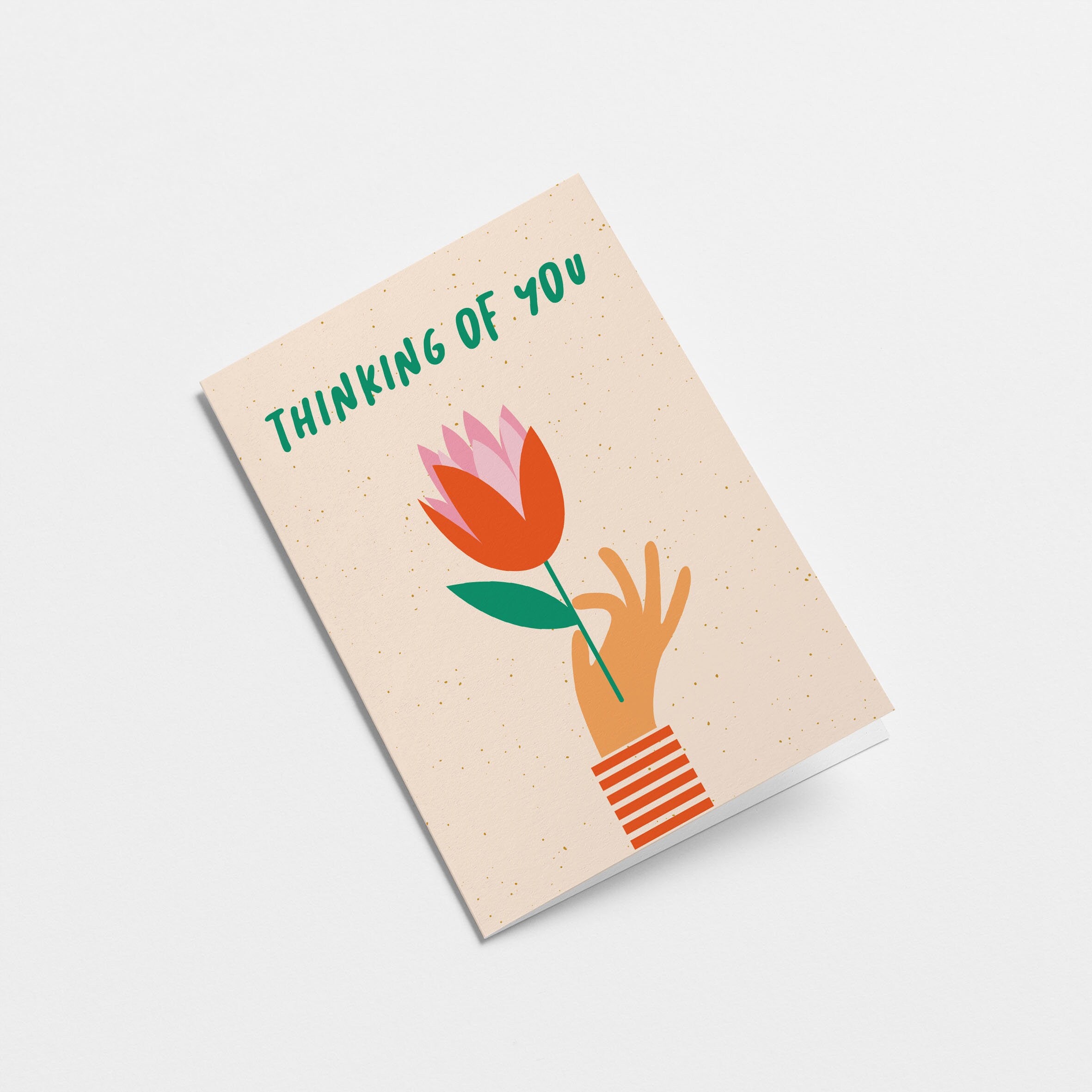 Thinking of you card with a hand holding red tulip and a text that says thinking of you