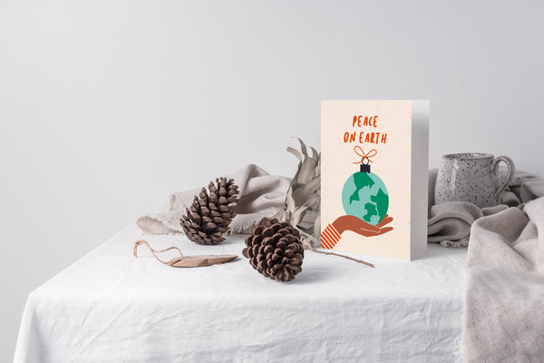 christmas card on a table with pinecones