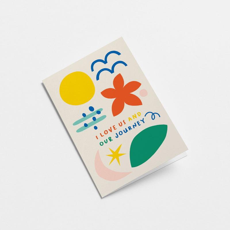 Love card with yellow sun, blue birds, red flower, green, pink, blue and yellow figures and a text that says I love us and our journey