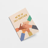 Friendship card with five different colored hands put on top of each other and a text that says we’re in this together
