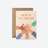 Friendship card with five different colored hands put on top of each other and a text that says we’re in this together