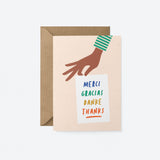 thank you card with a hand holding a white paper with a text in it that says Merci, Gracias, Danke 