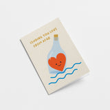 love card with a bottle that contains a red heart on sea and a text that says sending you love from afar