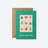 christmas greeting card with colorful letter stamps on a green card and a text that says happy christmas