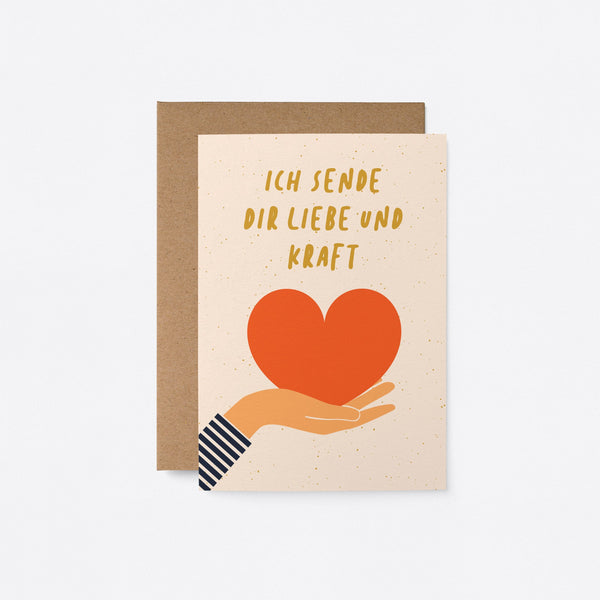 friendship and support card with a hand holding a red heart and a text that says Ich sende dir liebe und kraft. 