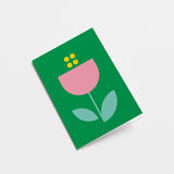 everyday greeting card with a green background and pink flower with blue leafs