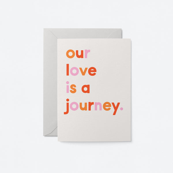 typographic greeting card and text says: our love is a journey. Grey envelope on white background.